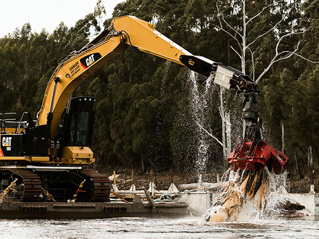 Digger Pulling Timber from Water